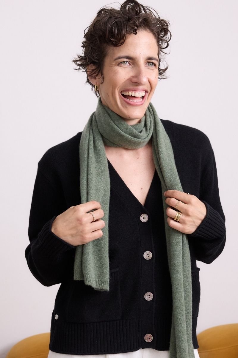 Cashmere Black Allure V Neck Cardigan Knit classic black cashmere V-neck cardigan with button front, ribbed trims and front pockets styled with a soft green scarf